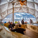 people in a white dome tent, winter landscape outside the window