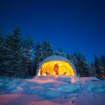 a pair of people in a white geodesic dome in winter