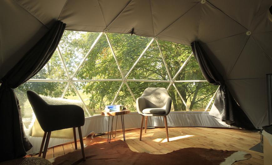 FDomes Glamping from the inside view on panoramic bay window and two armchairs