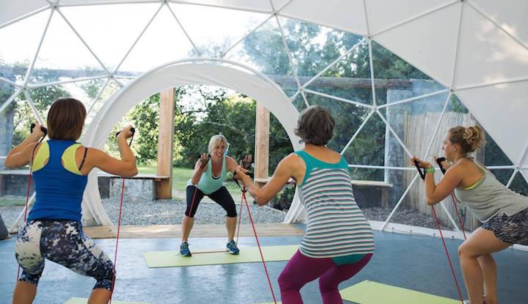women practicing yoga in a geodesic dome