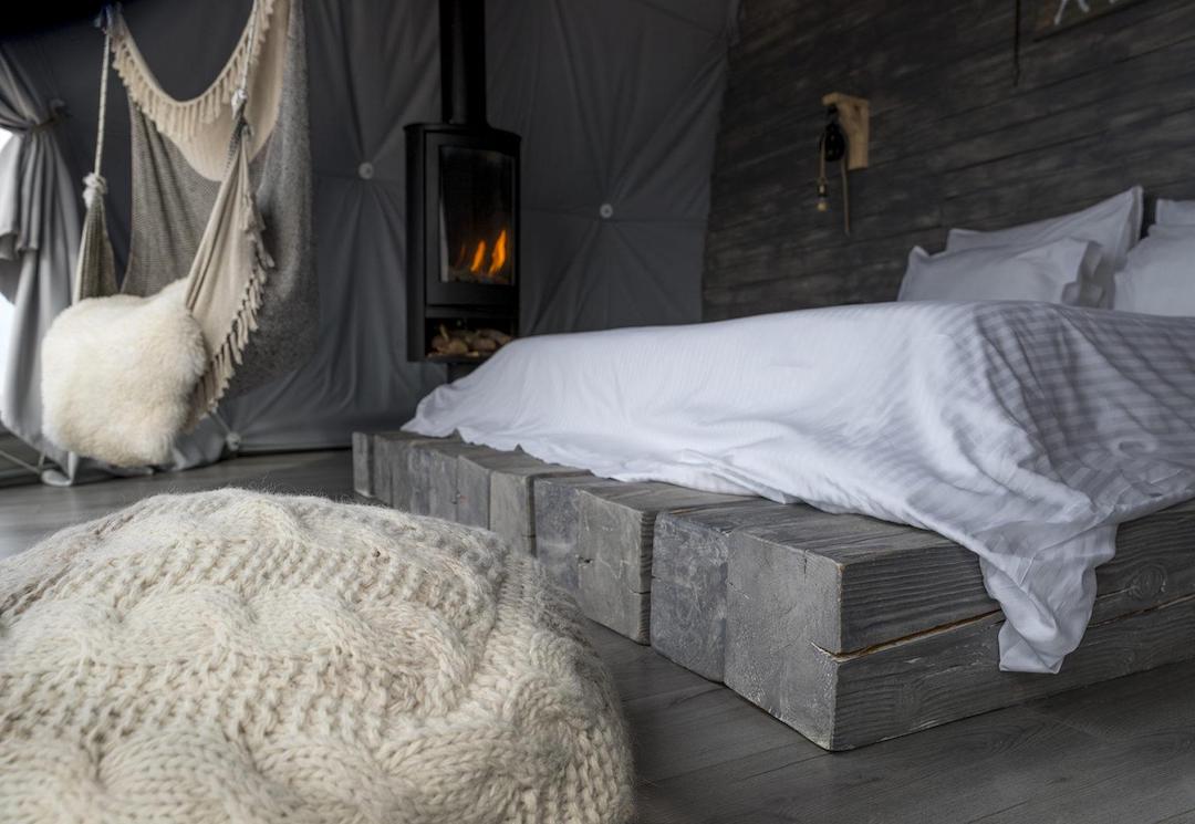 interior of geodesic dome with view at fireplace and bed