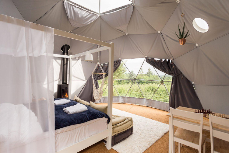 interior of geodesic dome with view at bed, window, table, the skylight