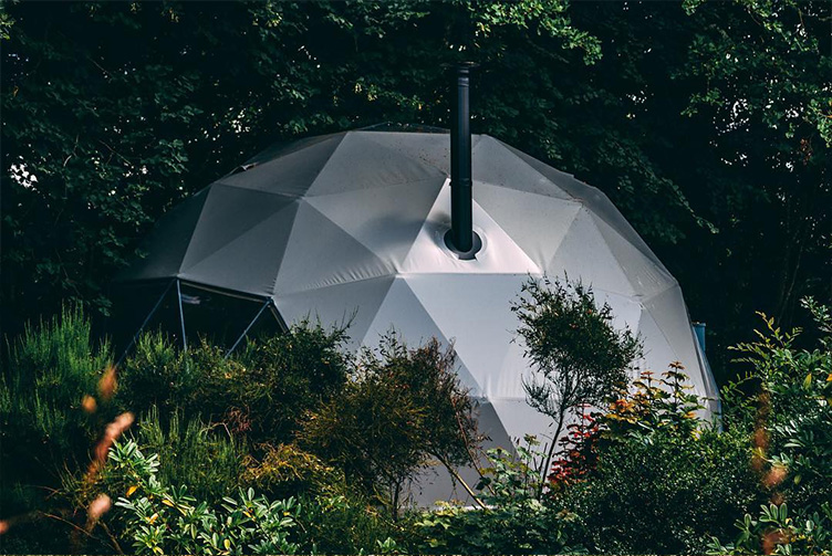 grey glamping geodesic dome in the middle of woods