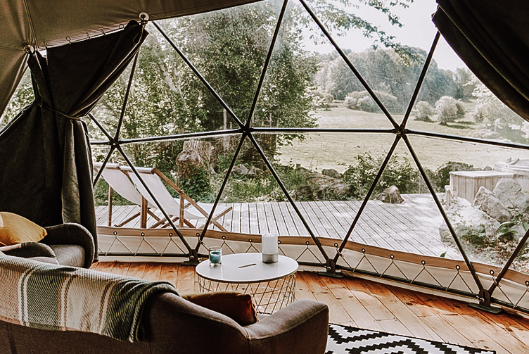 inside of geodesic dome with a sofa and a view on field