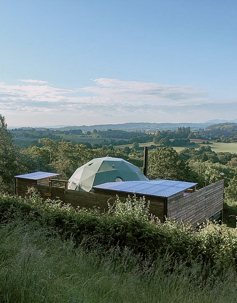 green geodesic dome with a view on fields