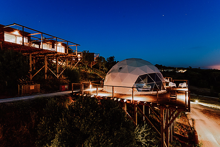 a white glamping geodesic dome on the mountainside in the night