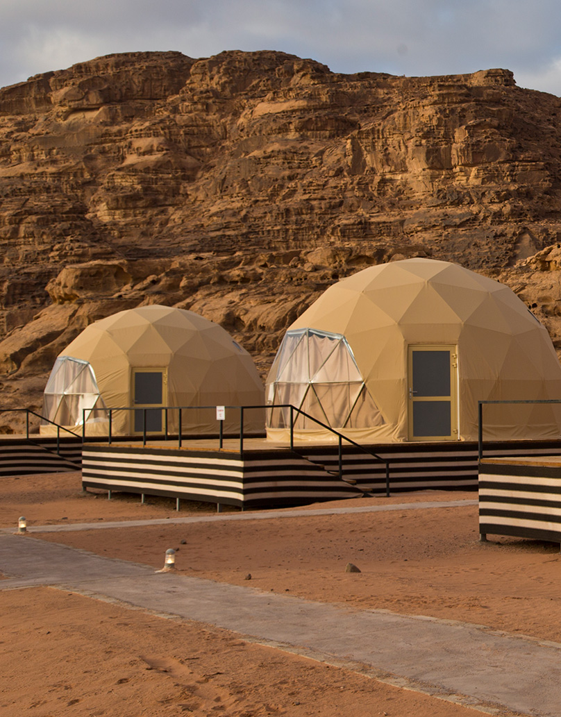 beige geodesic domes on wooden platform in the desert