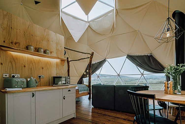 interior of geodesic dome with view at kitchen, window, table and the skylight