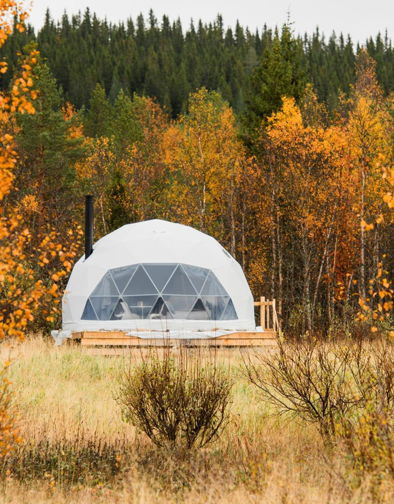 white geodesic dome with stack in forest in autumn