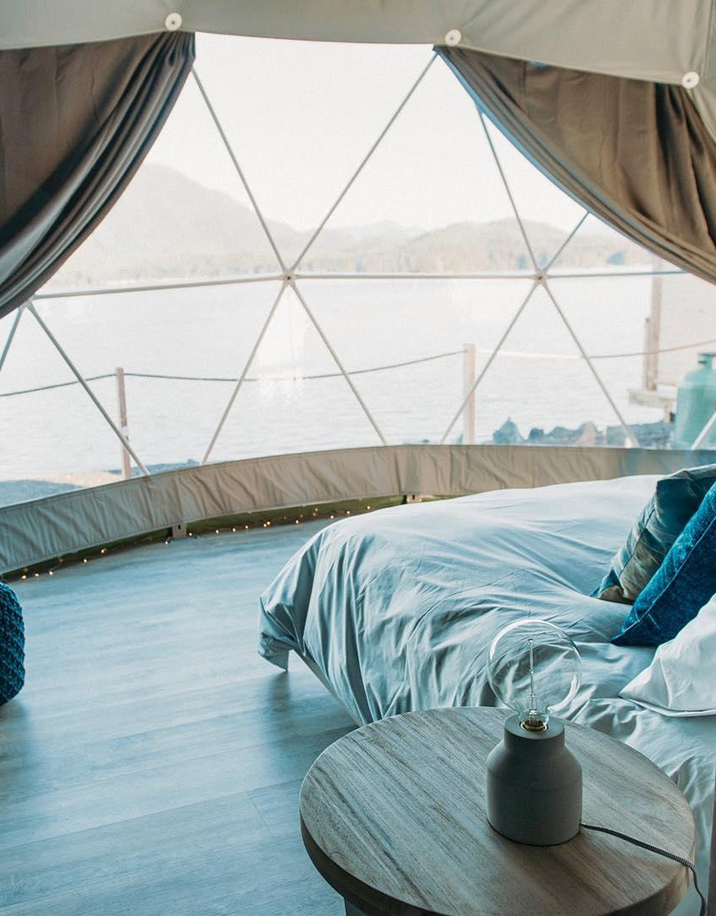interior of geodesic dome with view at window, bed, overlooking the water