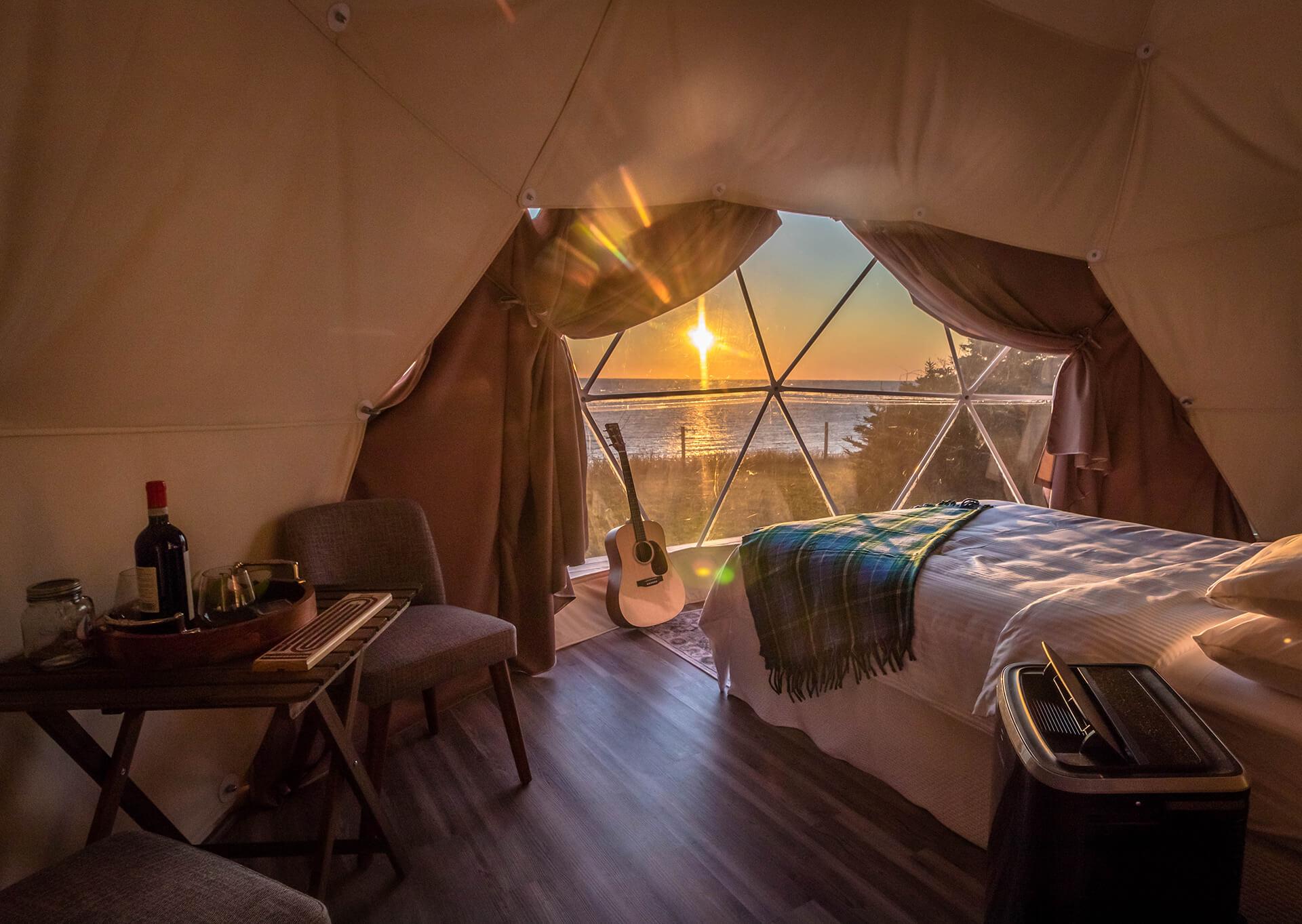inside a geodesic dome with view on bedroom and window with sunset