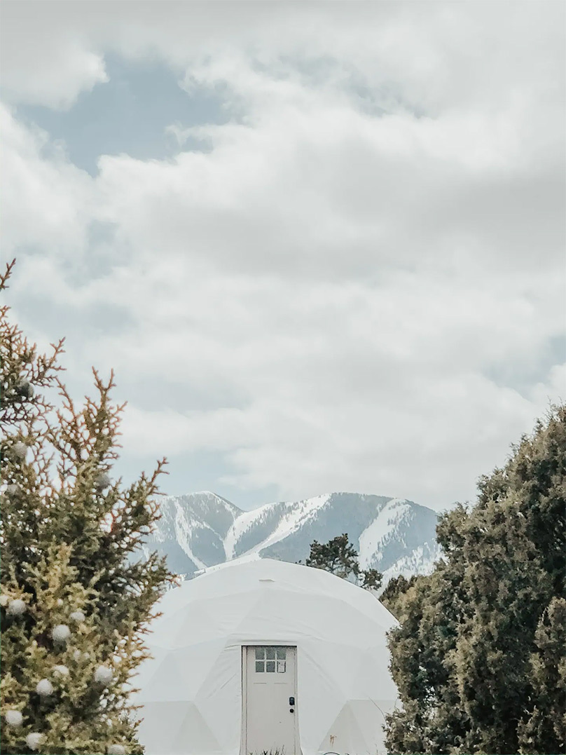 white geodesic dome in winter with mountain view