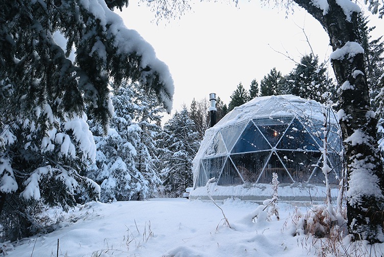 white geodesic dome with stack in winter in forest