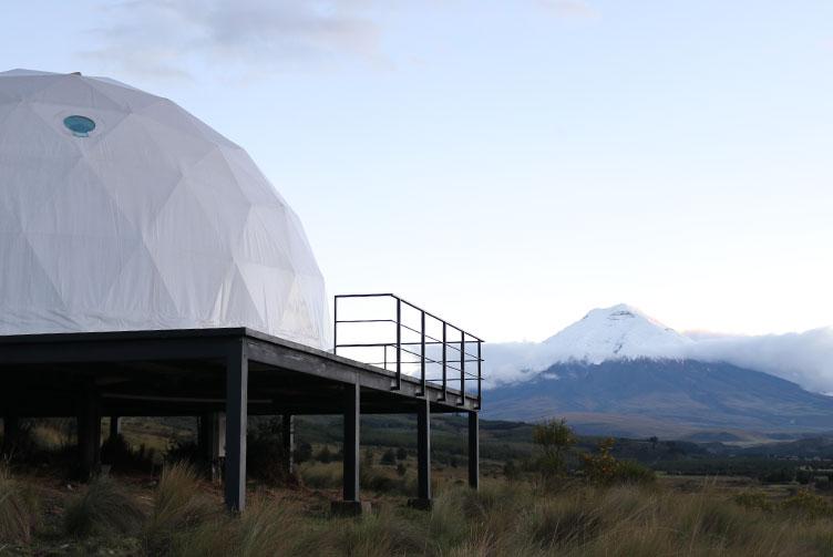 white geodesic dome against the background of a volcano