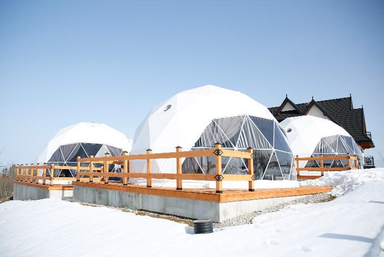 white geodesic domes located in the mountains in winter