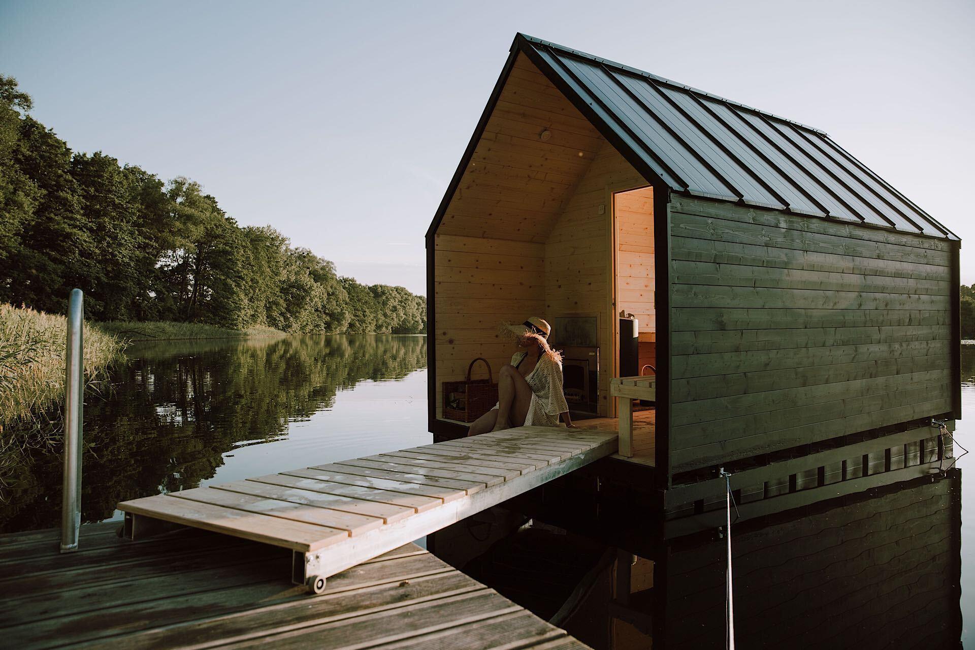 LAGO Sauna floating on the lake with wooden deck and a desk to get inside
