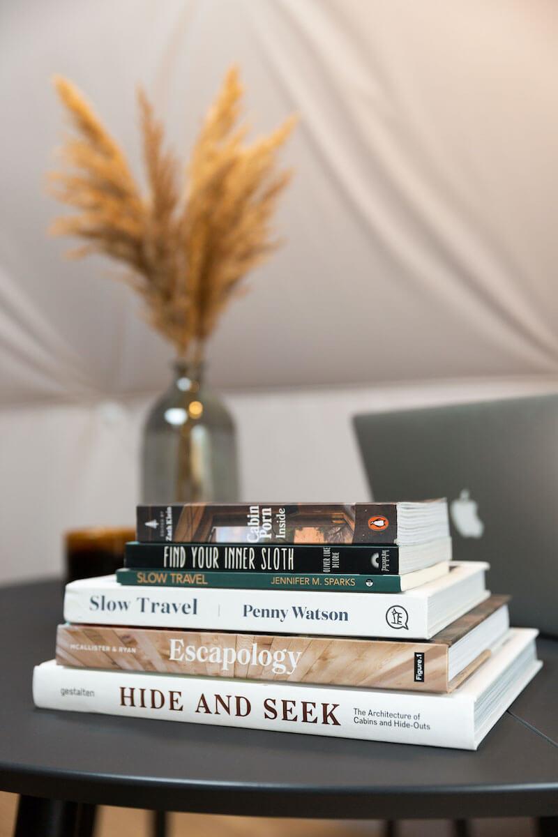 Pile of glamping books on the table inside of FDomes Glamping Showroom