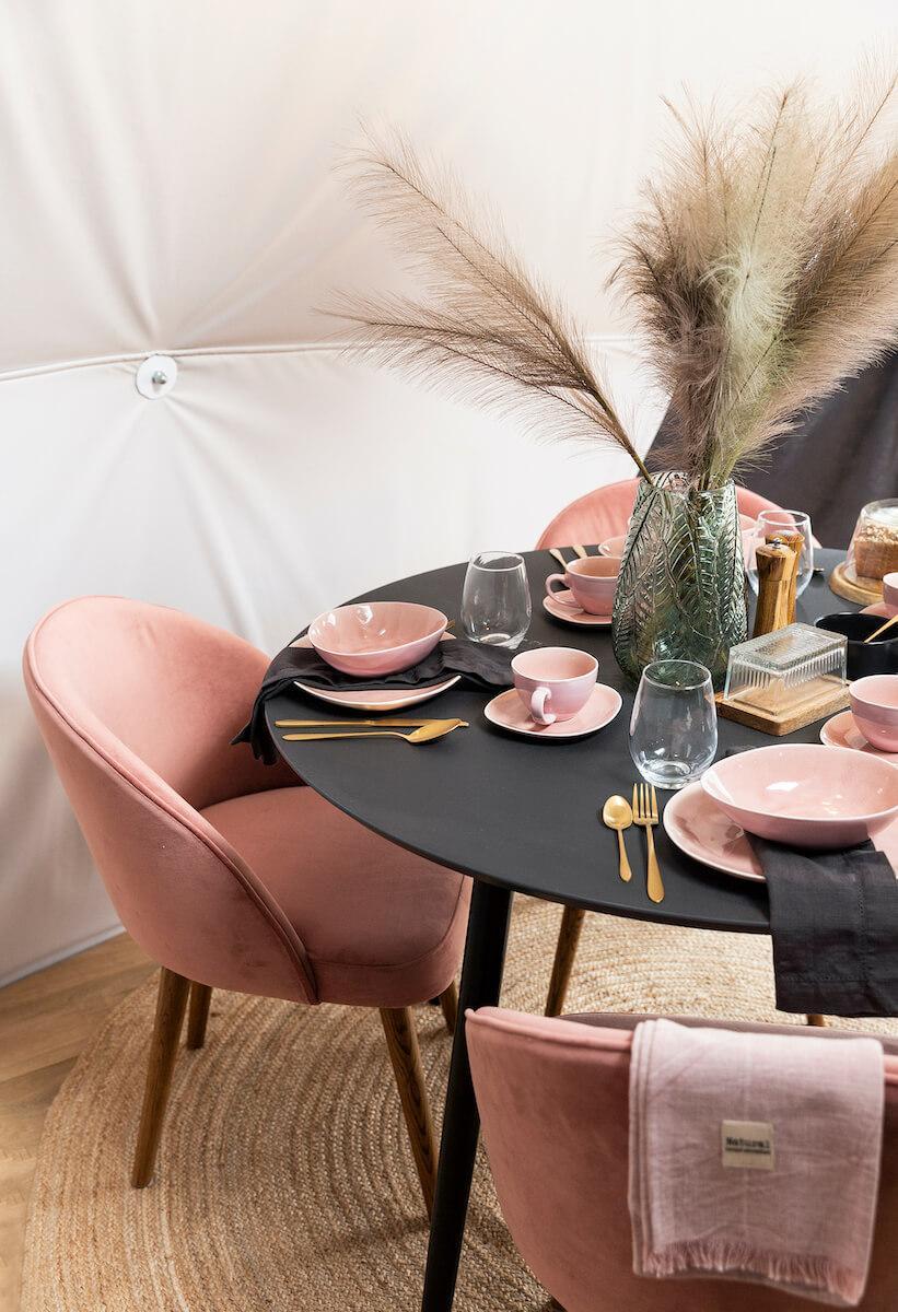 Kitchen table with pink chairs and accessories inside of FDomes Glamping Showroom