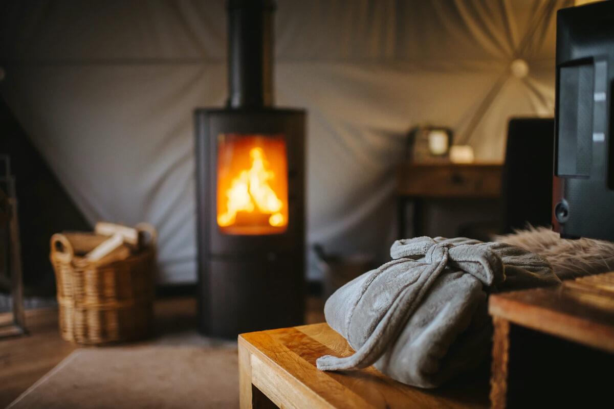 Wood-burning Stove in the back, slightly blurred, on the first plan a folded robe 