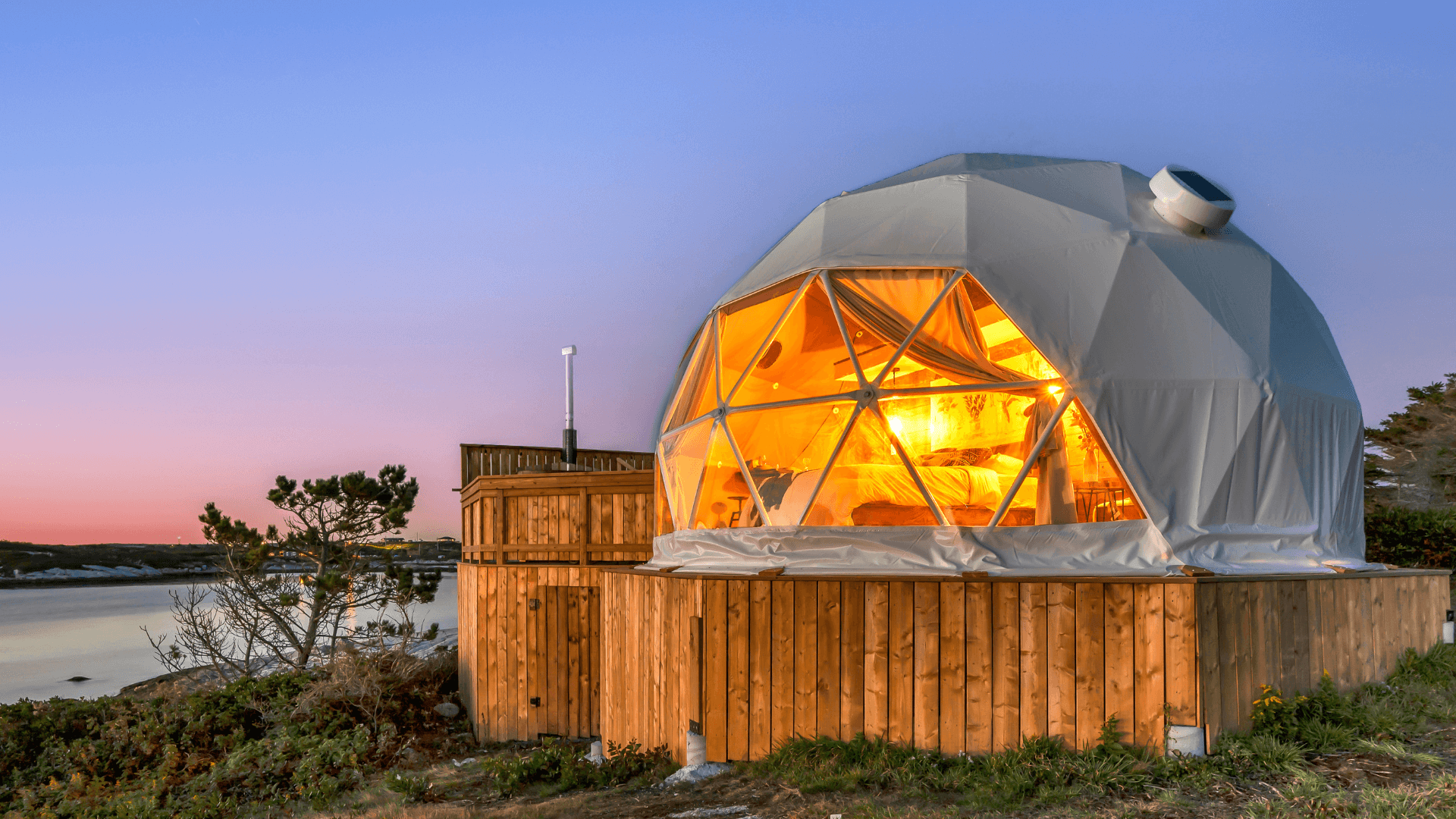 white geodesic dome on wooden deck on field