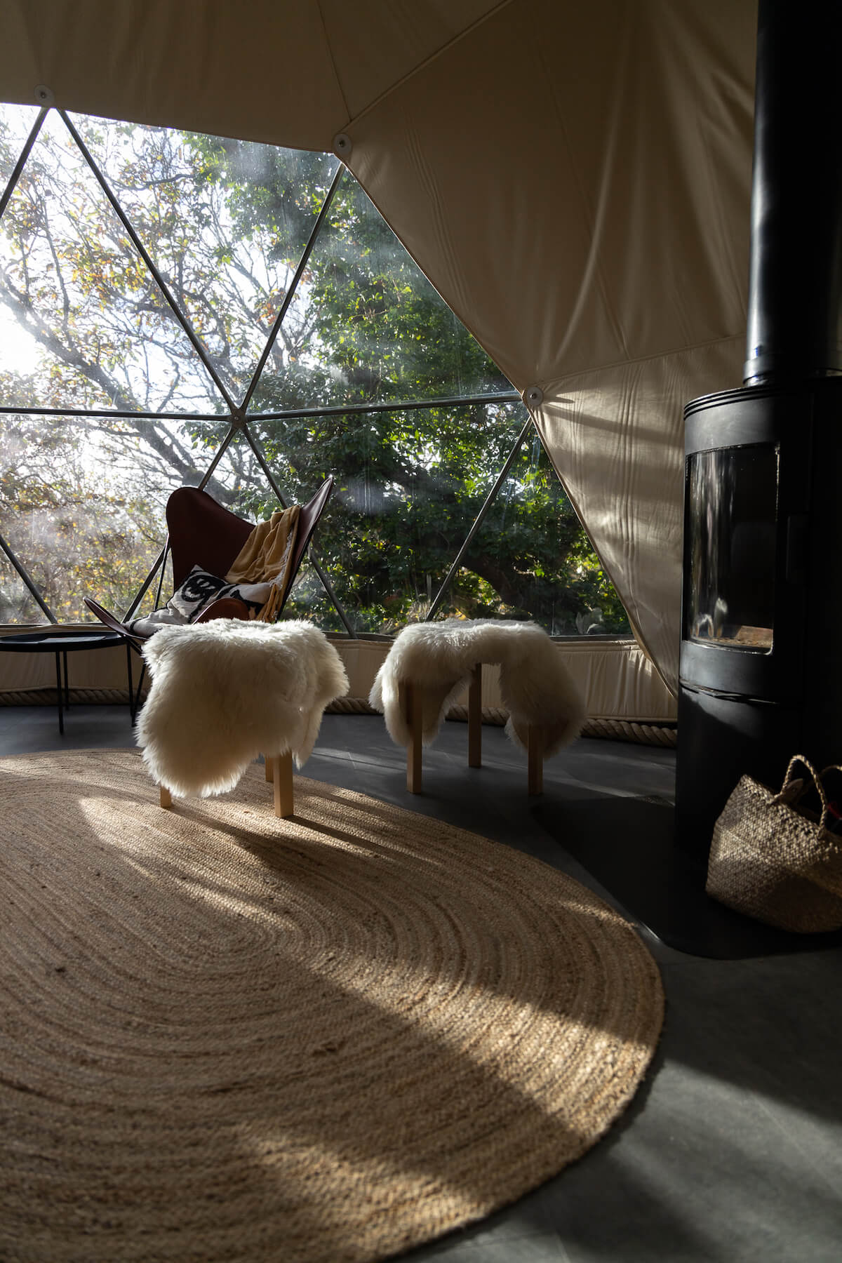 inside of geodesic dome with a stove, a chair and a window