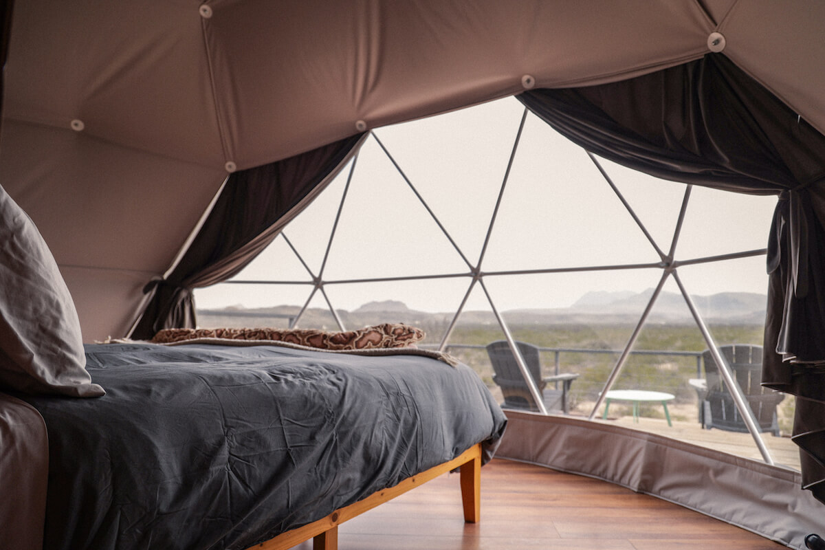 inside of geodesic dome with a bed and a window
