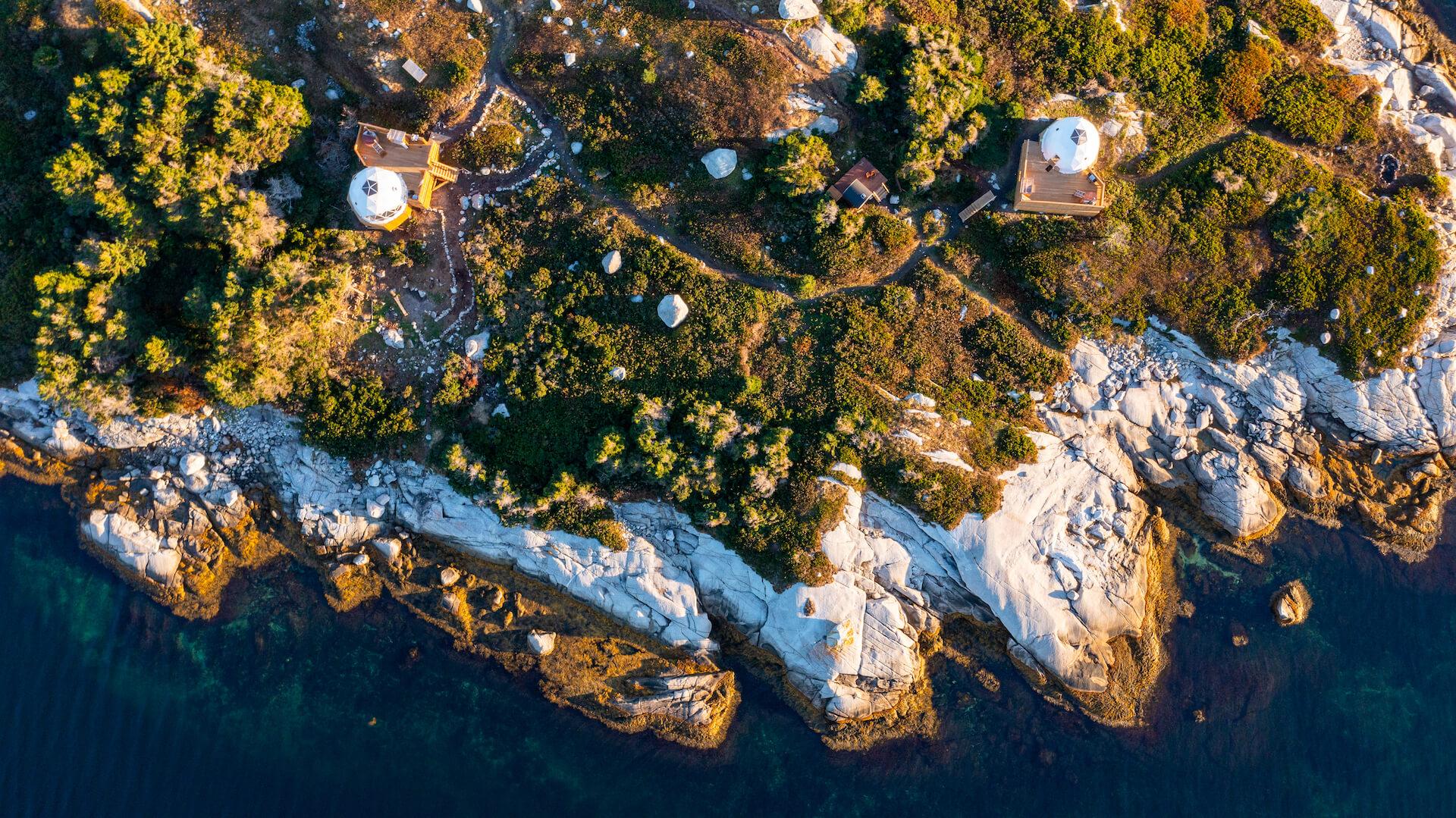 view from drone of two white geodesic domes on the island