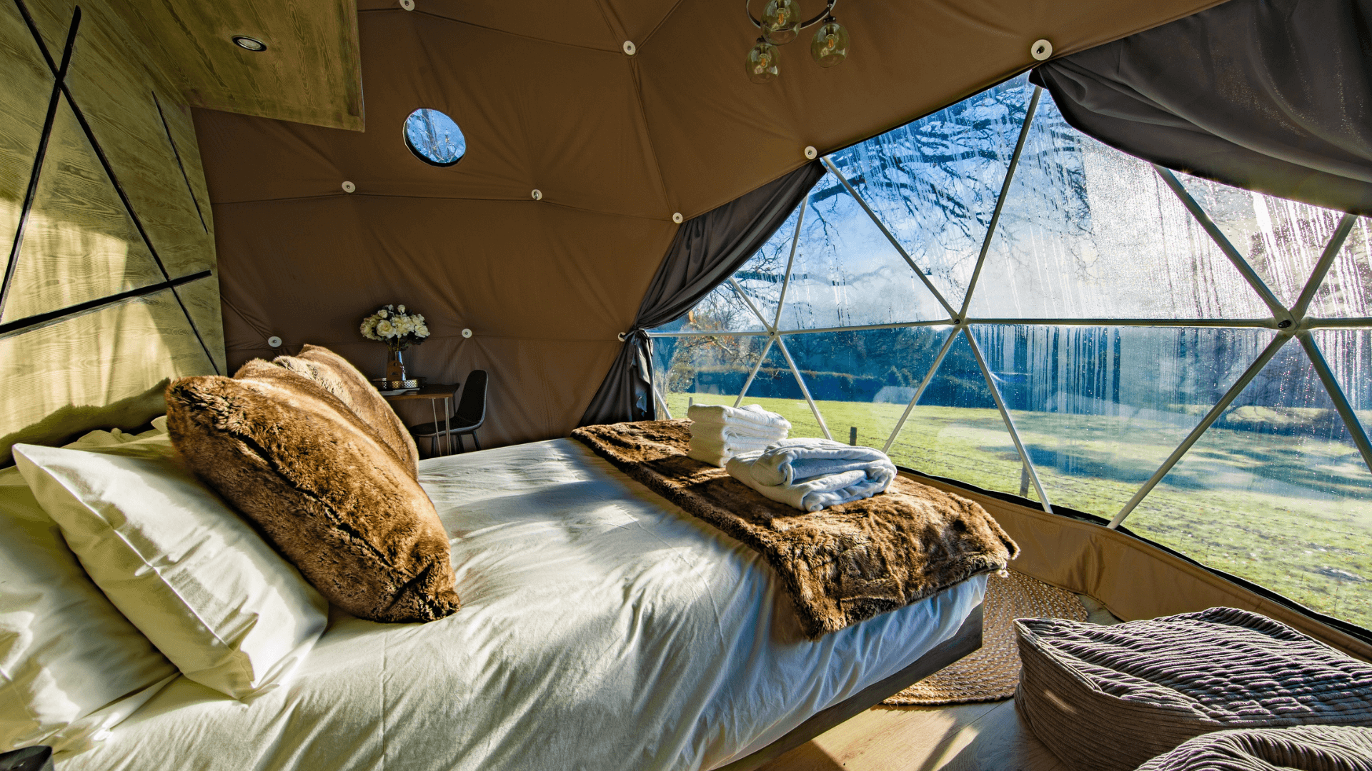inside of geodesic dome with a bed and a windows