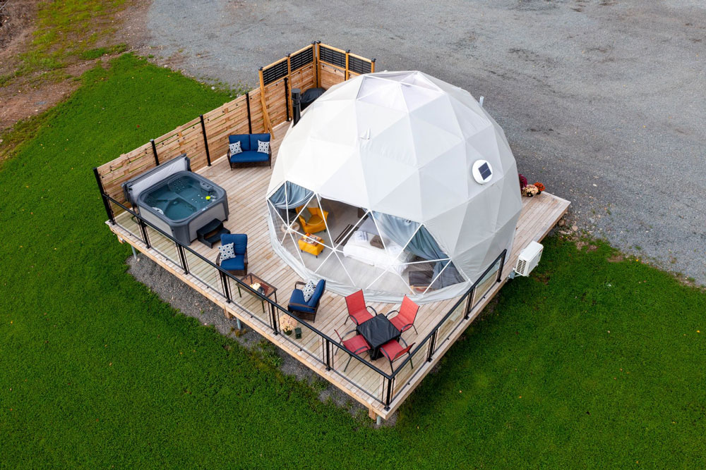 white geodesic dome on wooden deck with fully outdoor equipment and a jacuzzi