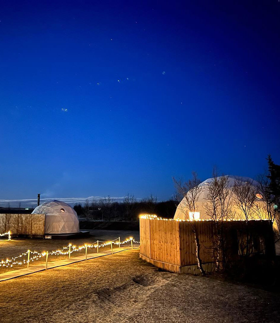 two white geodesic domes at night