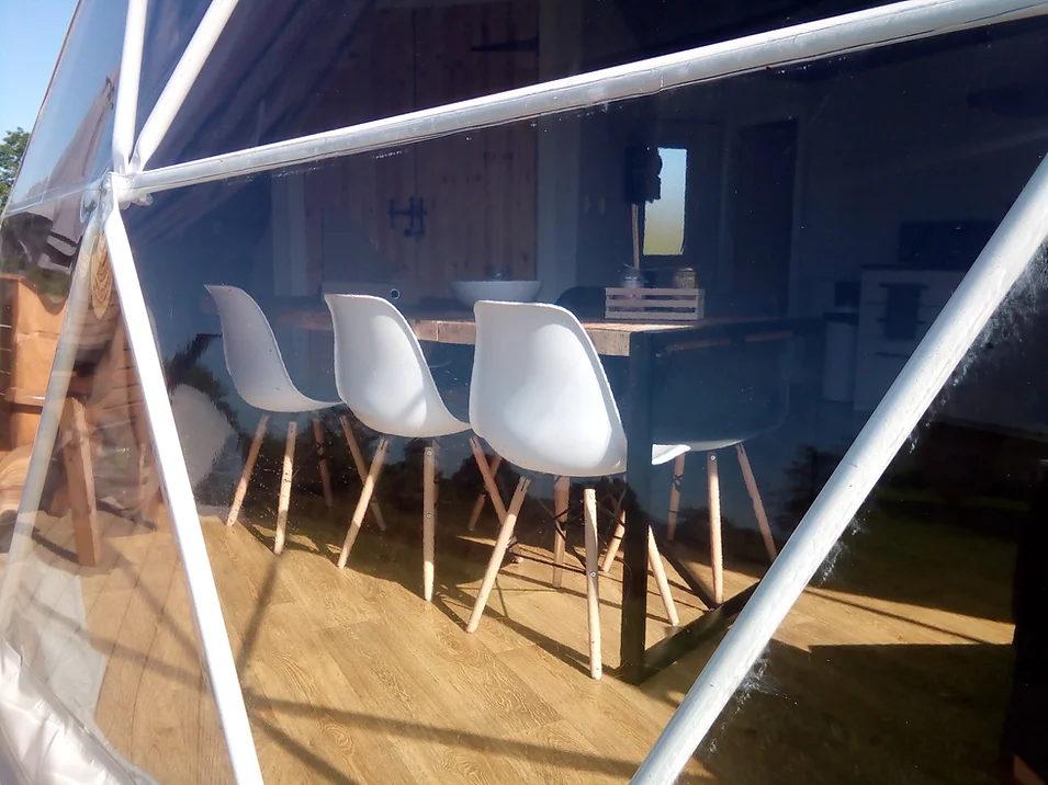 geodesic dome from window side with a view on some chairs and table inside