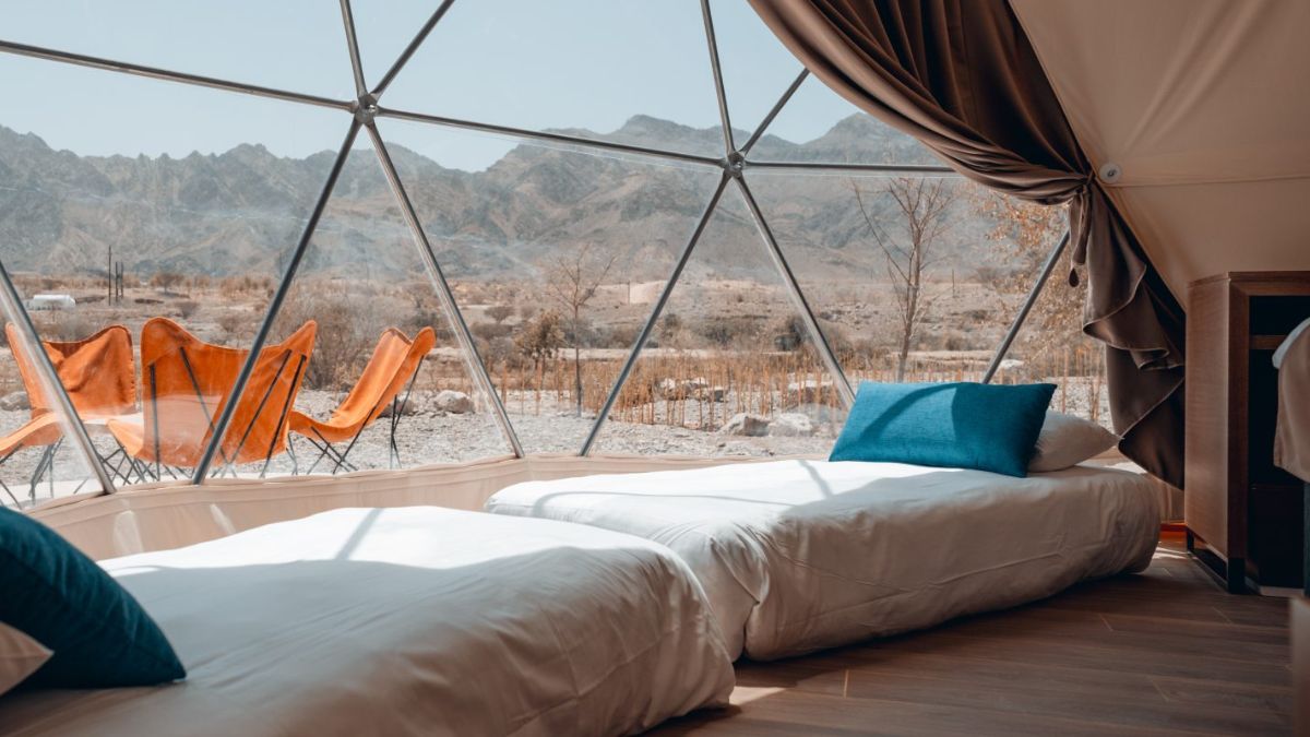inside of geodesic dome with two beds in front of window