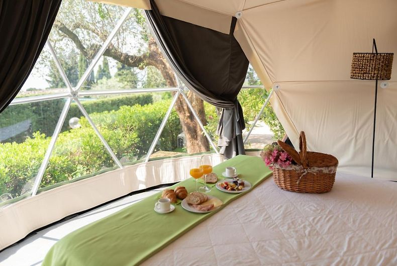 inside of geodesic dome with a bed and a window