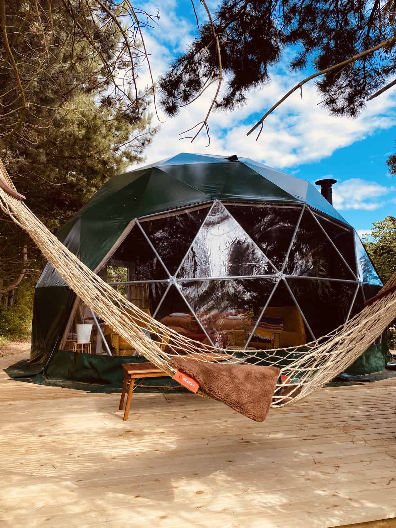 green geodesic dome on wooden deck with hammock