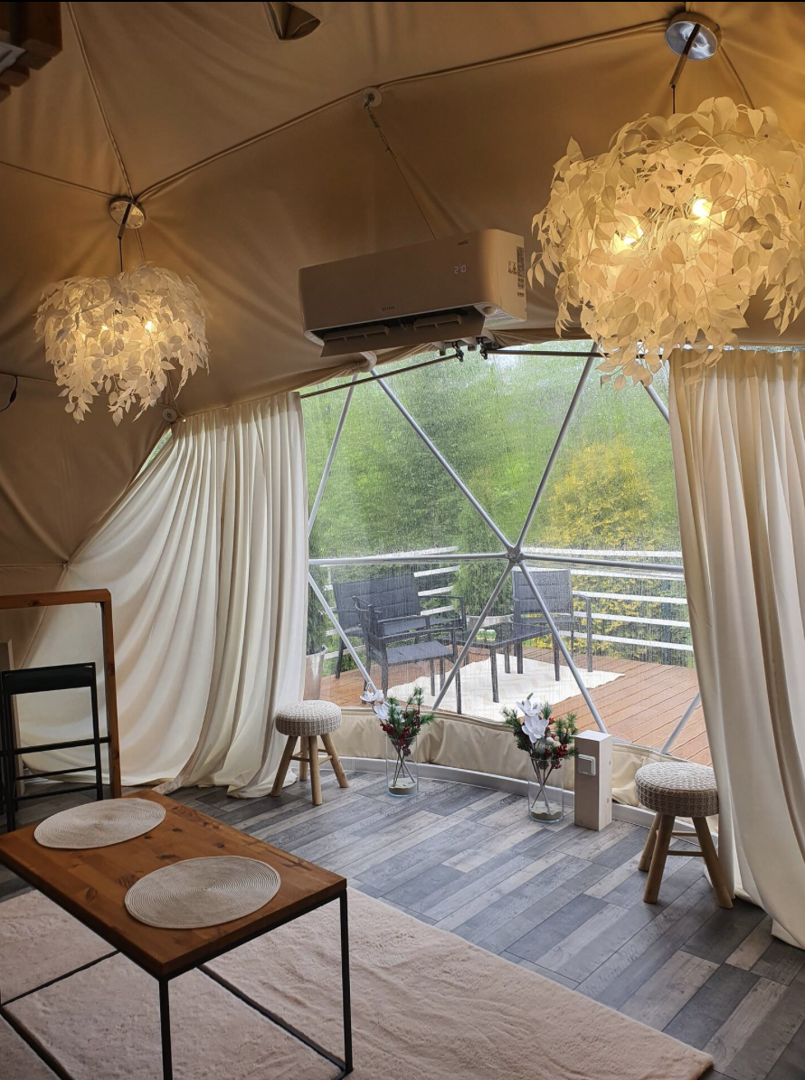 inside of geodesic dome with a big window and a table