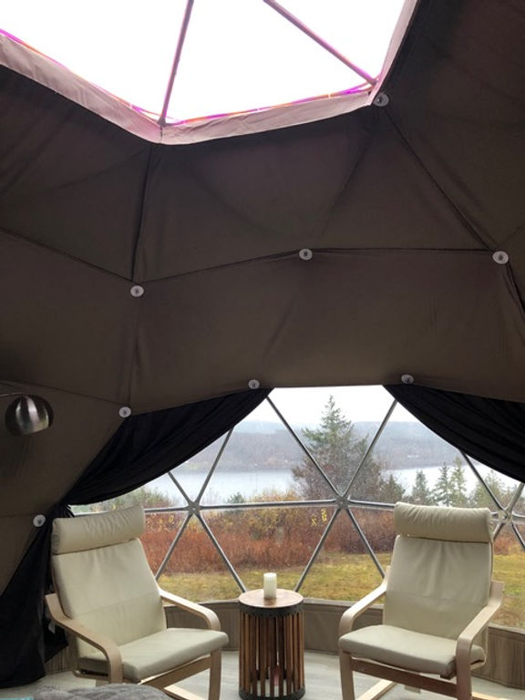 inside of geodesic dome with two armchairs and skylight