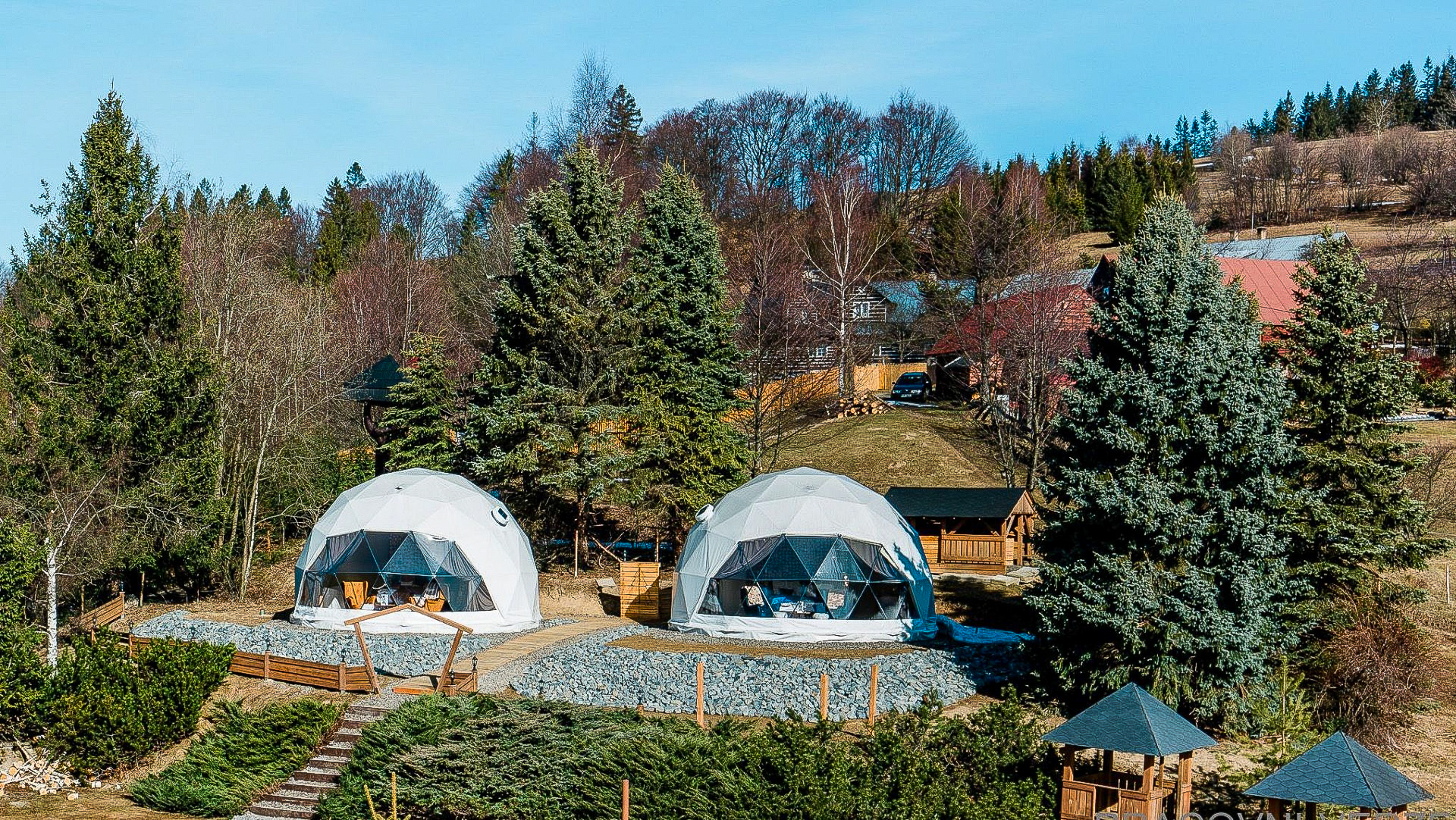 two grey geodesic domes on the hill