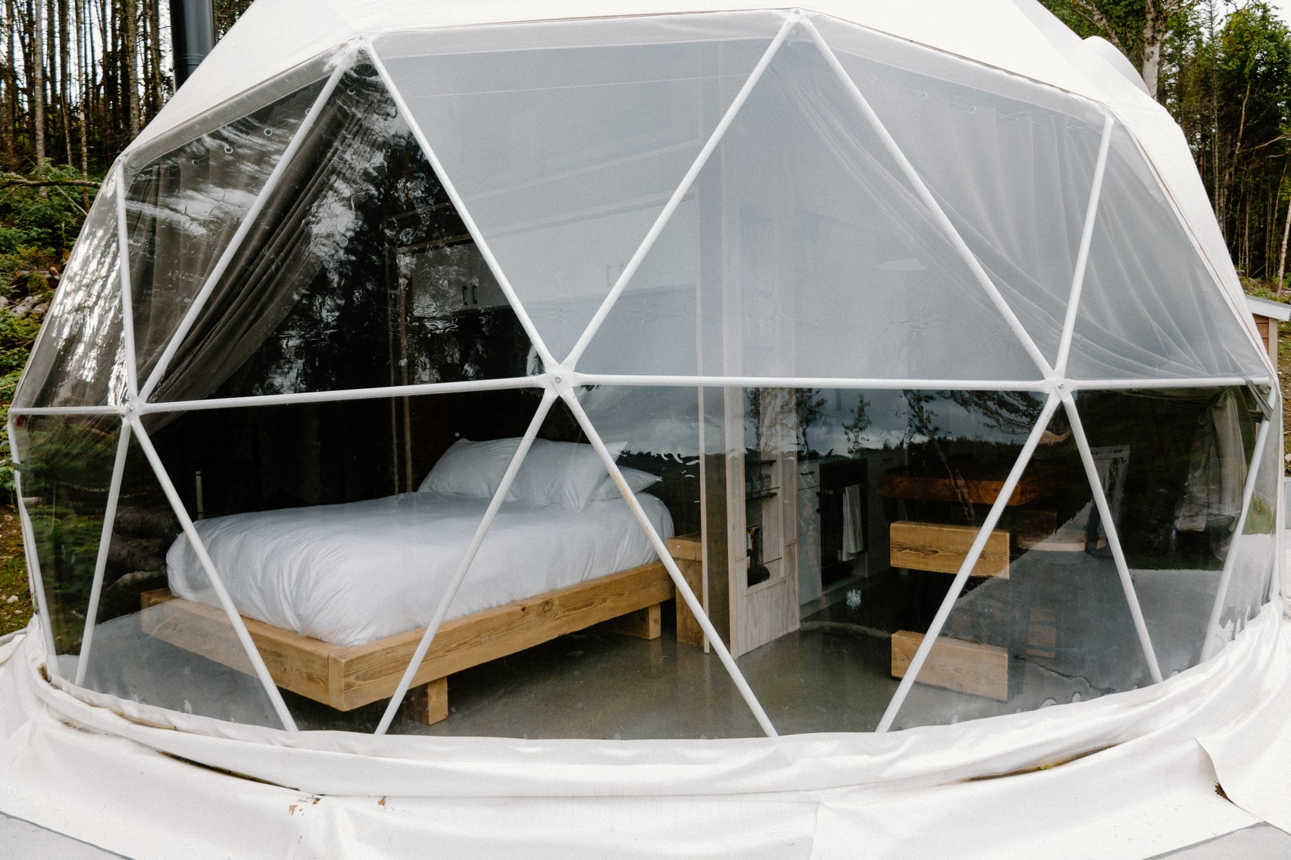 white geodesic dome from outside with a view of furniture inside
