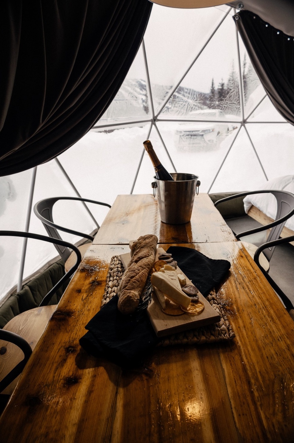 inside of geodesic dome with a table and some chairs with a snowy view