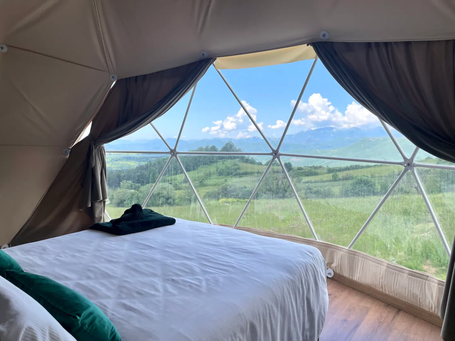 inside of geodesic dome with a bed and a view through window