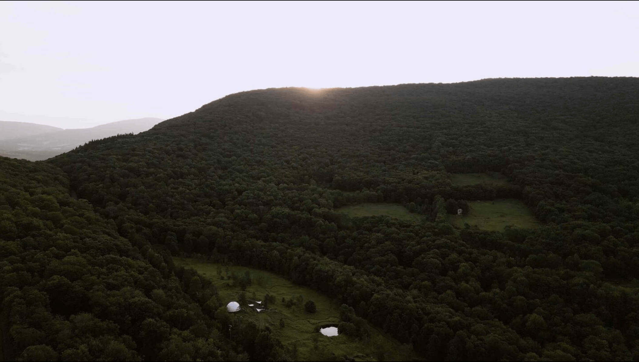 two white geodesic domes from a drone view