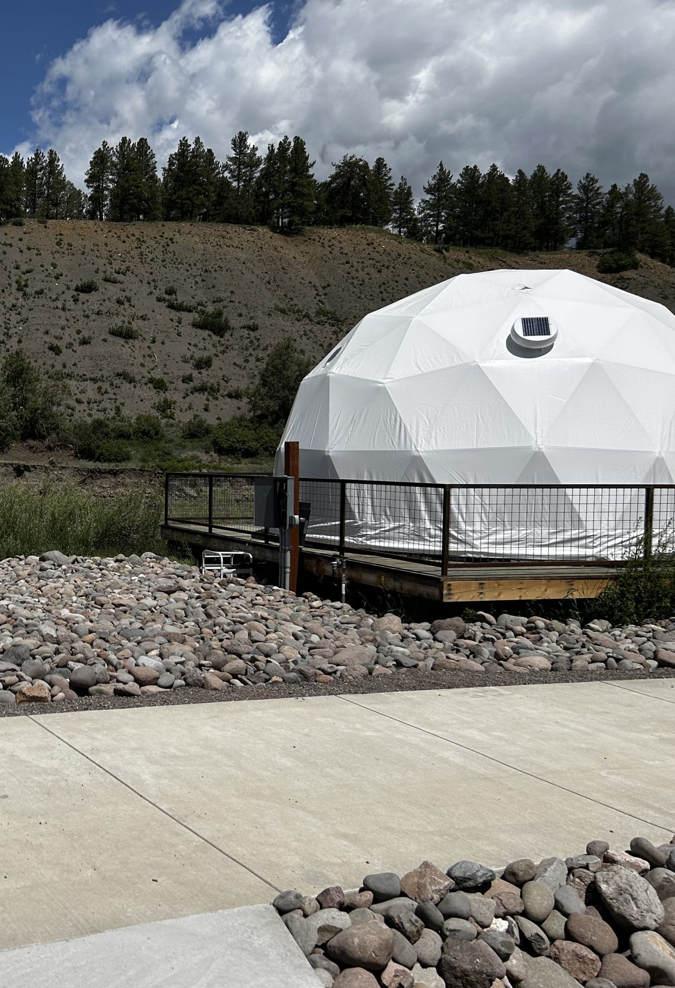 white glamping geodesic dome on a campsite