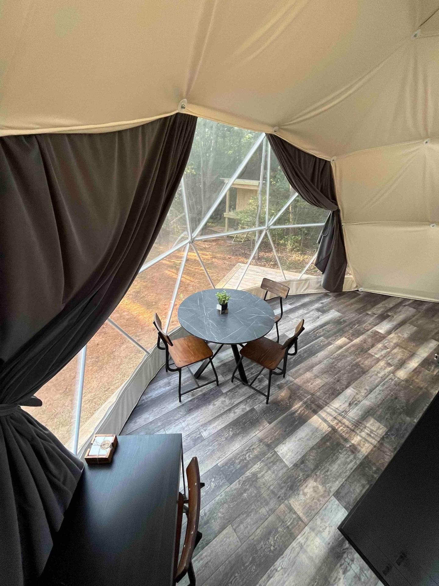 interior of geodesic dome with view window, curtains and coffee table