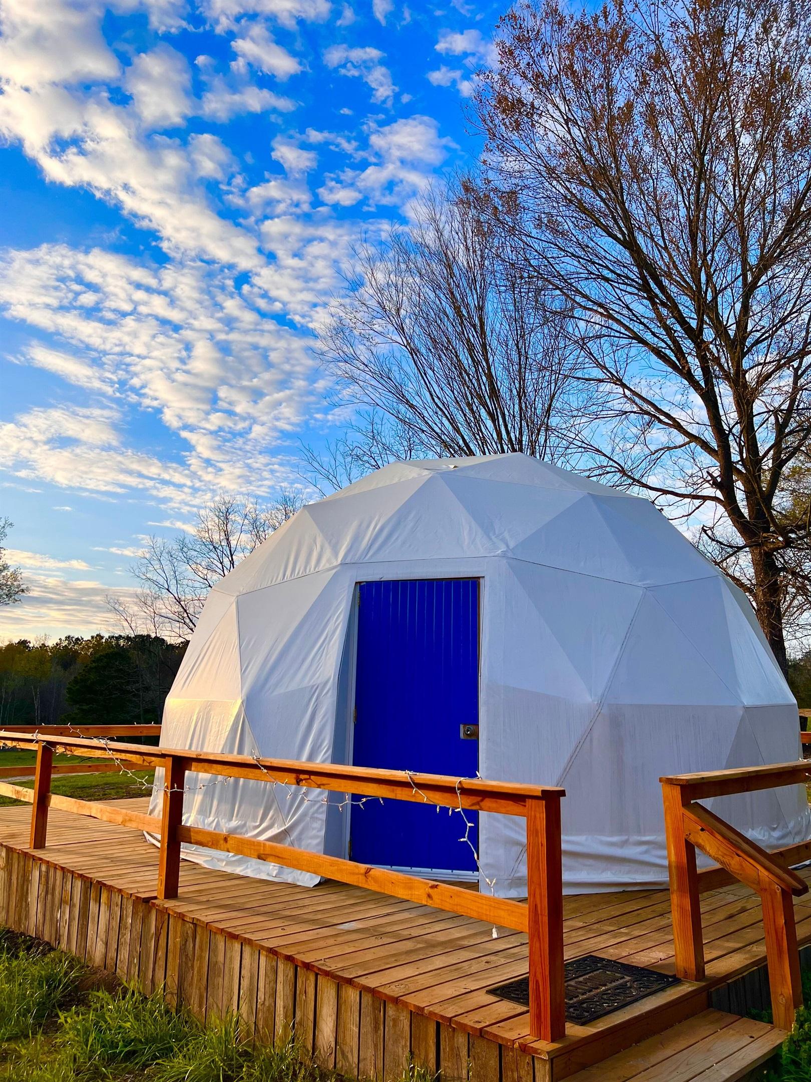 white geodesic dome with blue doors during the day