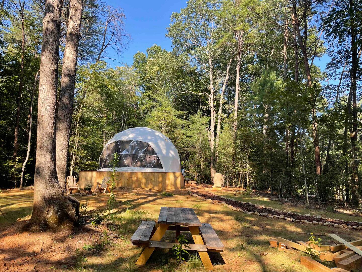 white geodesic dome at wooden platform in forest