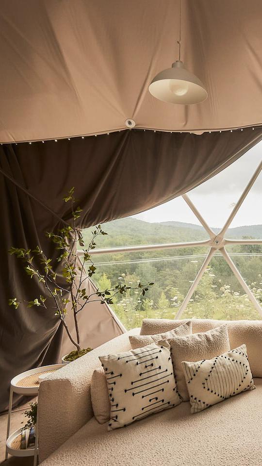 interior of geodesic dome with view of insulation, curtains, window and sofa