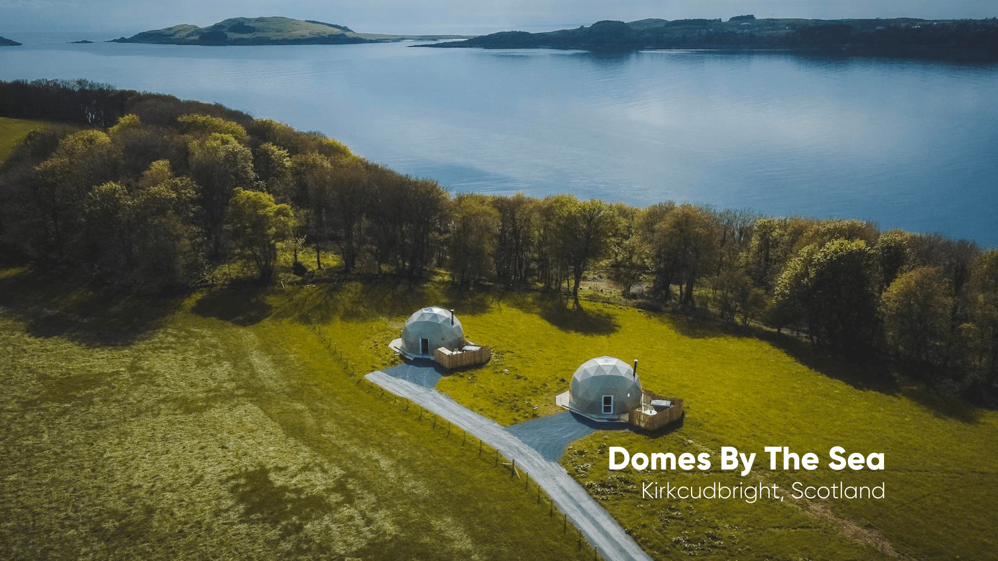 white two geodesic domes against the background of the lake and nature